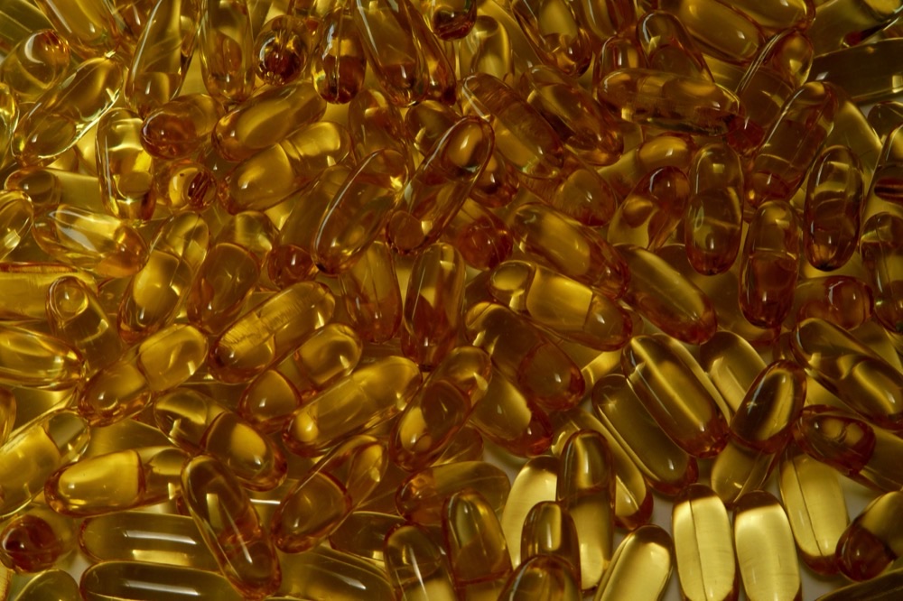 A pile of glossy amber softgel capsules