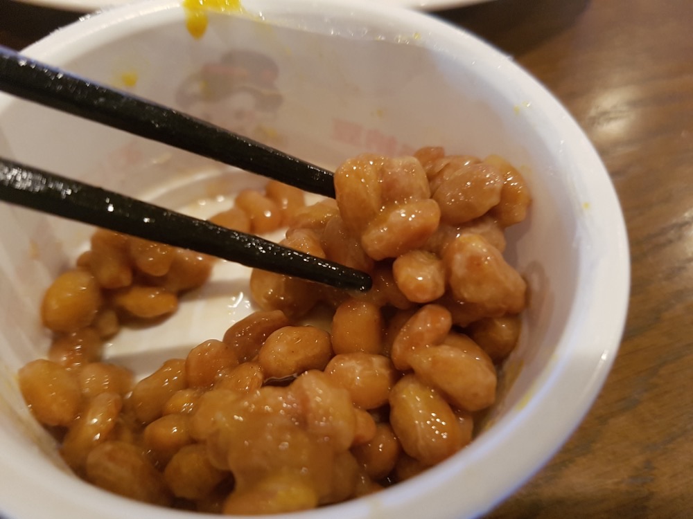 A bowl of natto, sticky fermented soybeans, eaten with chopsticks