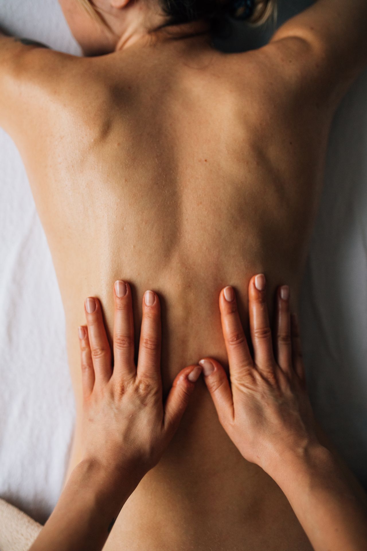 Hands releasing tension in a person's back muscles