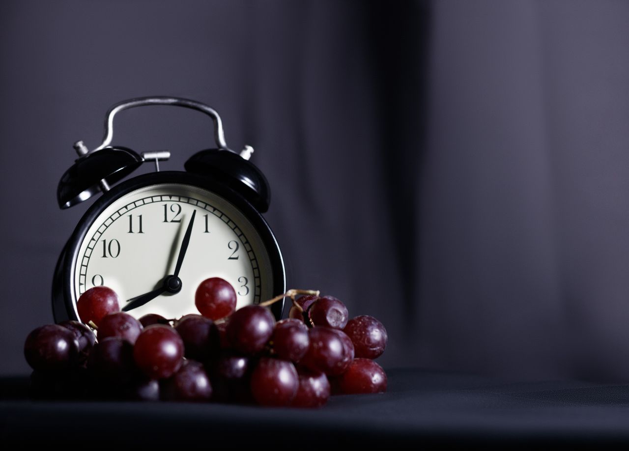 Clock alongside fresh food representing a timed eating window