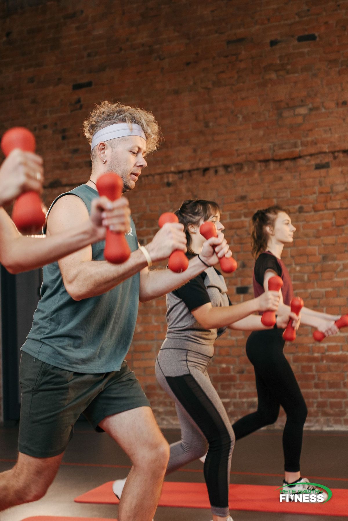 Three people training with dumbbells in a group session