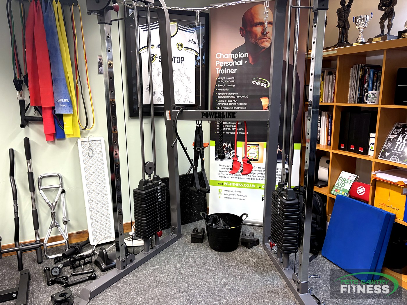 Pete Gawtry's private North Leeds studio — cable crossover machine, resistance bands and his Champion Personal Trainer banner and trophies