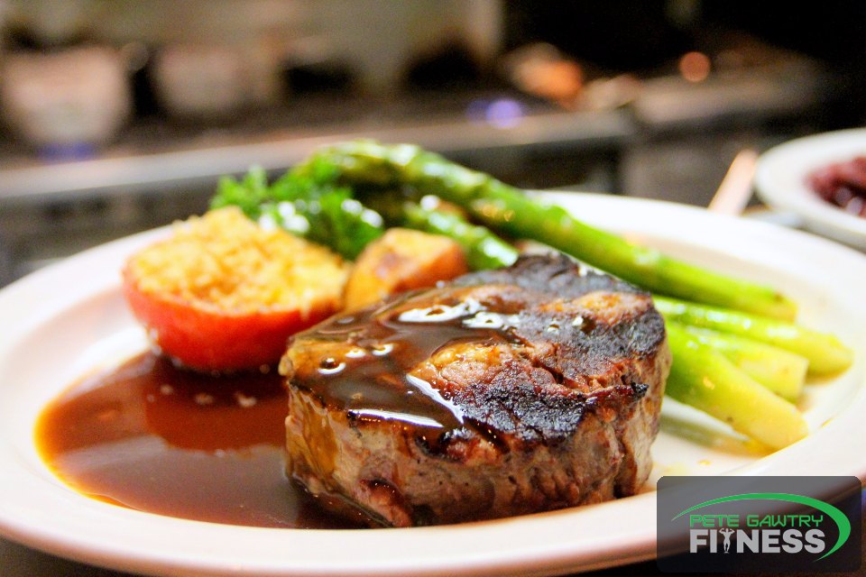 A plated dinner of steak, asparagus and tomato — real, satisfying food