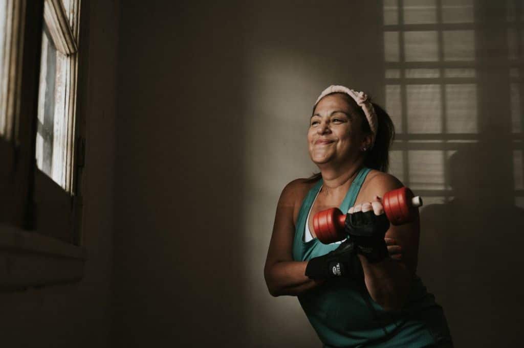 Smiling mature woman exercising with dumbbells