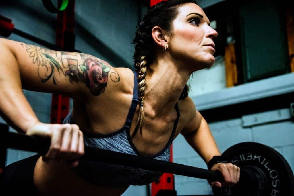 Athletic woman lifting a barbell in the gym